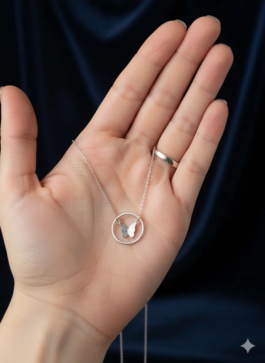 Hand holding Shinora Midnight Fly Pendant – elegant silver butterfly necklace showcasing fine craftsmanship from Shinora