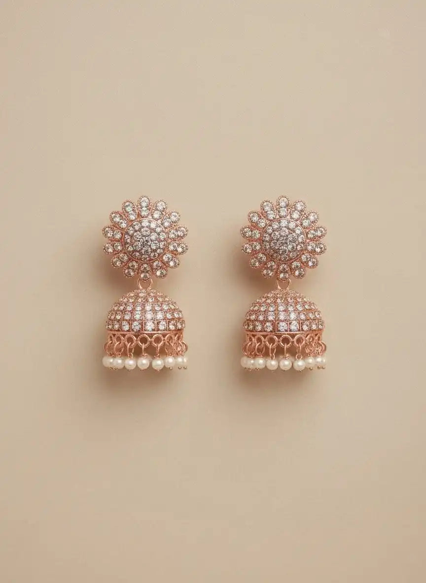 Noor Jhumka – rose-gold jhumka earrings with shimmering stones and delicate pearl drops on a neutral background from Shinora