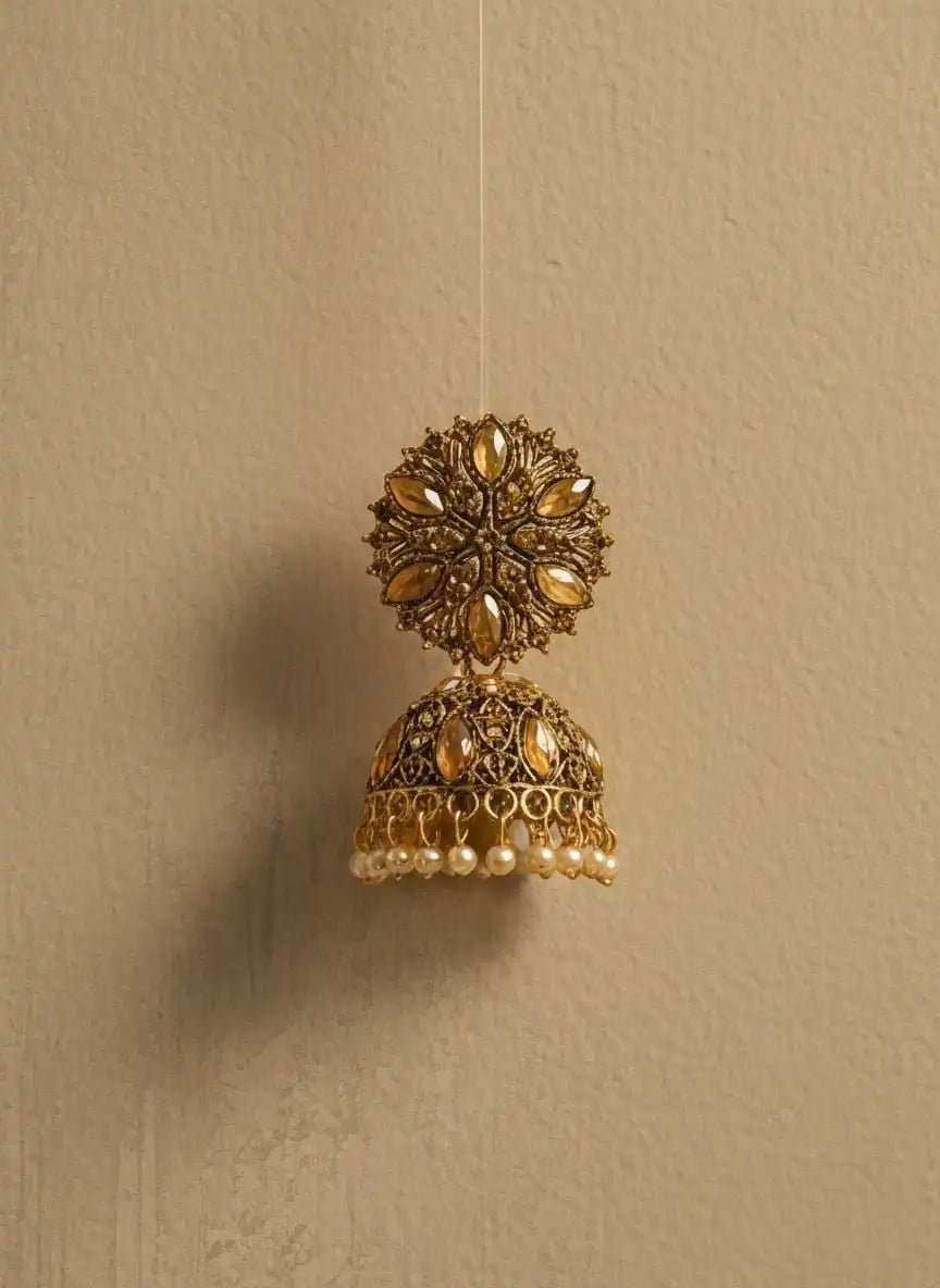 Heer Jhumka – single antique gold floral jhumka earring with dangling pearls on beige textured wall from Shinora