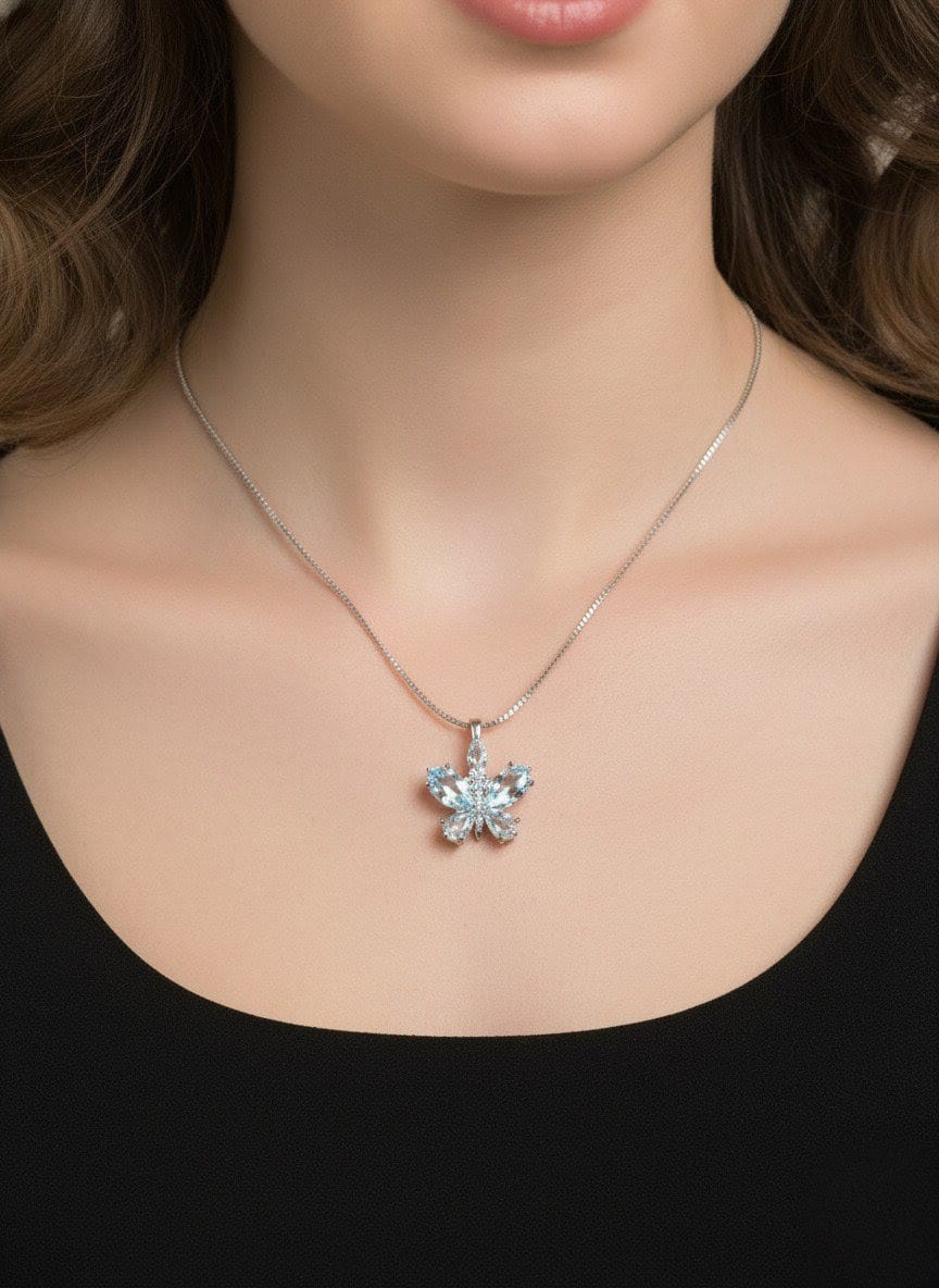 Close-up of The Fluttering Charm butterfly pendant necklace with clear crystal stones on a sleek silver chain, displayed on dark background  by shinora