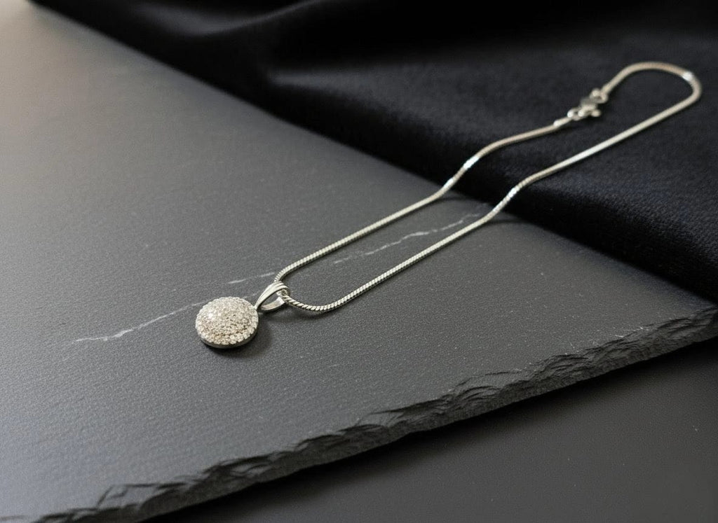 Luxury silver chain necklace with circular crystal pendant showcased on dark slate with black velvet fabric – The Celeste Necklace by The Fluttering Charm by Shinora