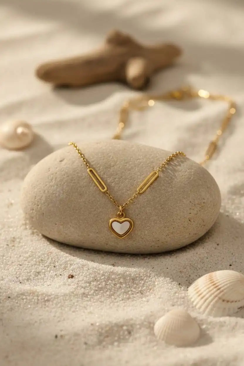 Floral Heart Necklace with white pendant hanging in front of green leaf backdrop, luxury jewelry photo by shinora