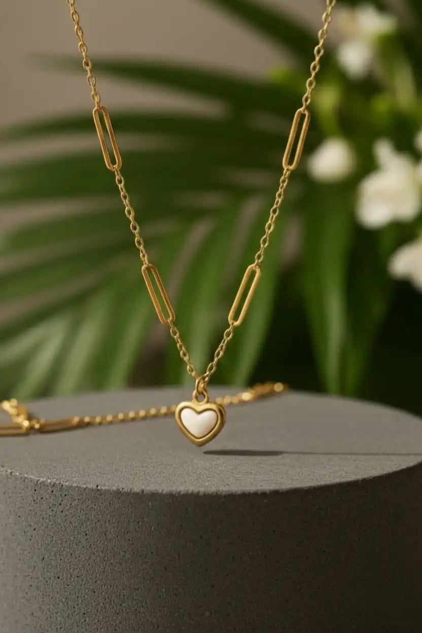 Floral heart pendant necklace displayed on stone and sand, aesthetic jewelry flatlay for product showcase by shinora