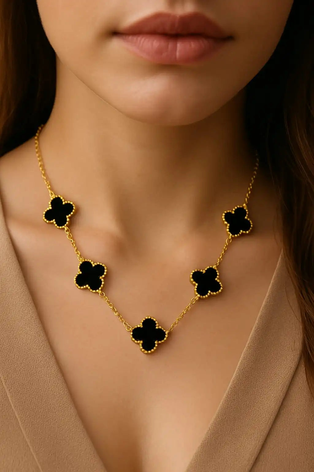 Gold clover necklace with black enamel charms worn by a woman, close-up jewelry shot for elegant styling form shinora