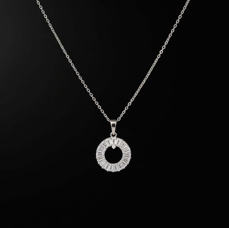 Silver necklace with a circular pendant on a black background from Shinora