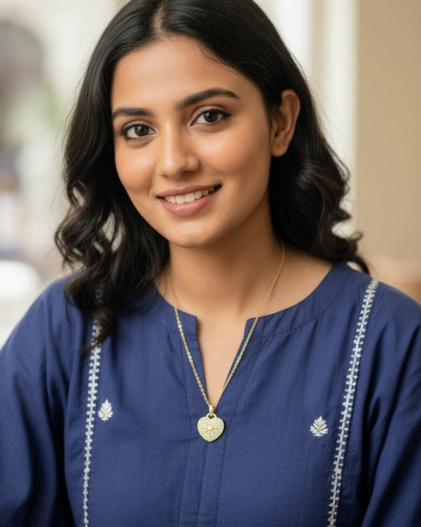 Woman wearing the Aurum Heart Necklace – dainty gold heart pendant paired with a blue kurta for a minimal everyday look from Shinora