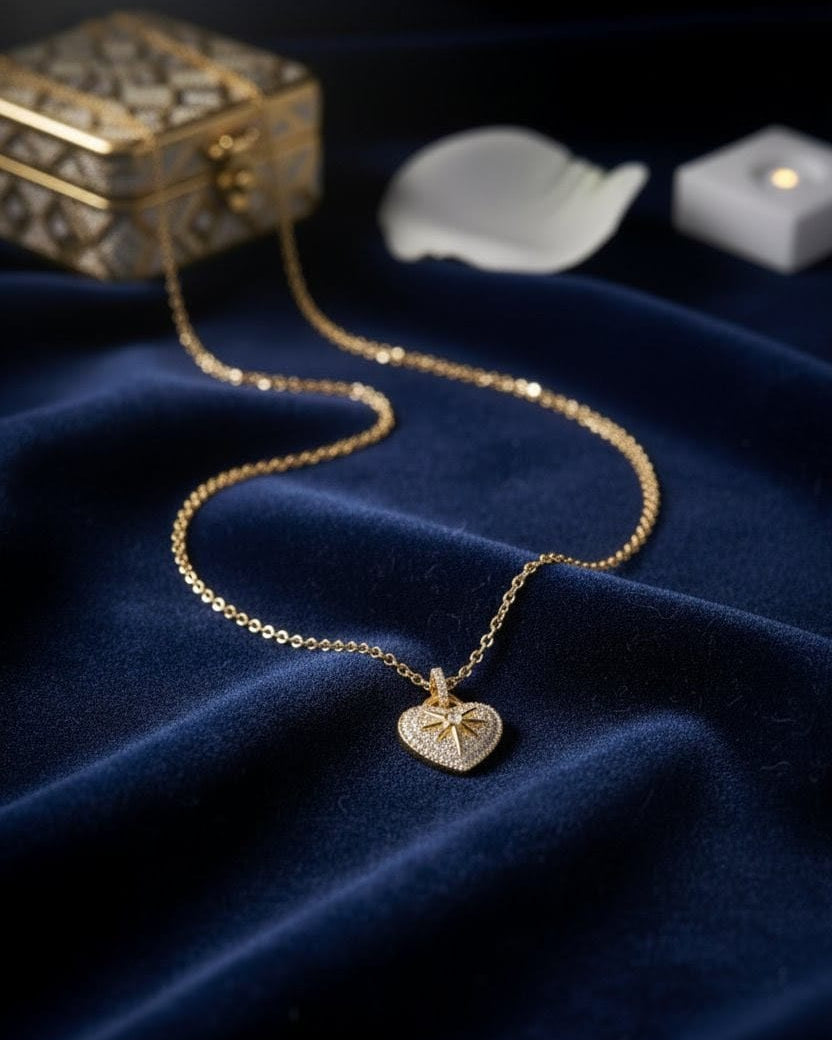 Close-up of the Aurum Heart Necklace on blue velvet – gold heart pendant with star-inspired detailing and shimmering stones from Shinora